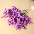 Vista detallada de las flores de paniculata artificiales de seda violeta en madera - Púrpura