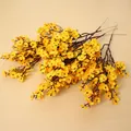 Vista detallada de flores de gipsófila artificiales amarillas sobre fondo de madera - Naranja