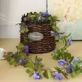 Detailansicht einer lila künstlichen Rosenrebe über einem Korb zur Dekoration - Blau