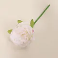 Vista de cerca de una sola peonía artificial de color blanco crema con hojas verdes - Blanco lechoso