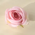 Vista macro detallada de una cabeza de rosa artificial rosa sobre una mesa de madera clara - Violeta Claro