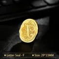 Vintage gold oval metal wax seal head with elegant engraved letter F floral motif - Letter F