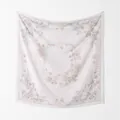 Gedetailleerde weergave van een elegante vierkante sjaal met bloemenprint aan de muur - 110*110cm / Beige (Bloemen)
