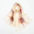 Vue détaillée de l'élégant foulard en mousseline de soie à imprimé floral, léger et aéré. - Beige