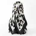 Detailed view of an elegant leopard print satin square scarf tied stylishly as a headscarf - 70*70cm / FH172-02# Black and White