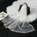 Élégante écharpe en organza blanc avec motifs de strass ondulés et perles fines. - Blanc