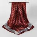 Detailed view of a high-end red silk square scarf featuring polka dots and paisley borders - Burgundy / 90x90cm