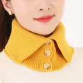 Vista detallada de un calentador de cuello de punto amarillo con tres botones. - Amarillo jengibre