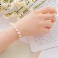 Elegant pink strawberry quartz beaded bracelet for women shown on wrist with flowers. - Rose Quartz Bracelet