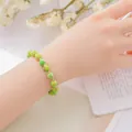 Elegant green beaded bracelet with gold spacer beads on wrist - Emperor Stone Bracelet