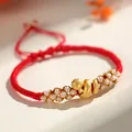 Hand-woven red rope bracelet featuring a gold snake charm and delicate pink floral knots - Lucky Snake Peach Blossom Knot / Red