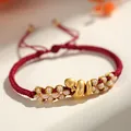 Hand-woven Year of the Snake red string bracelet featuring a cute golden snake charm - Lucky Snake Peach Blossom Knot / Dark Red