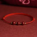 Red rope bracelet featuring three natural Nanhong agate beads and gold-tone spacers - Cinnabar Braided Cord Style