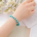 Elegant blue turquoise style beaded bracelet with gold spacers worn by model for women - Turquoise Bracelet