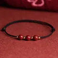 Bracelet artisanal en cordon noir avec perles de cinabre et accents dorés pour chance - Bracelet Noir