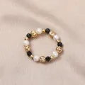 Elastic ring with natural white freshwater pearls, black beads, and gold hollow accents. - Freshwater Pearl (Black Spinel)