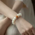 Natural Bodhi root bracelet featuring white beads with a single amber accent on a wrist. - Yellow Bodhi Style / Single Loop Style / Cream
