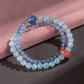 Elegant double-strand aquamarine beaded bracelet with a red agate ping'an kou bead. - Aquamarine Kyanite Safety Button Bracelet