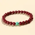 Dark red cinnabar beaded bracelet with a single turquoise accent bead - 6mm Purple Cinnabar With Turquoise