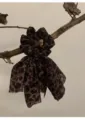 Chouchou léopard vintage avec longs rubans en forme de nœud exposé sur une branche rustique - Chouchou Noeud Léopard