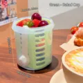 Portable green fruit salad cup with internal strainer and fork, ideal for healthy picnics - Green