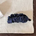 Gros plan sur la texture du tissu à pois bleu marine de la pince à cheveux banane plissée - Pince Banane Plissée à Pois / Bleu marine