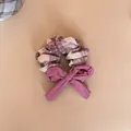 Macro detail view of a checkered plaid hair scrunchie featuring a purple fabric bow accent - Bow Scrunchie / Pink Purple Plaid