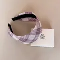 Detail view of a purple and white plaid wide headband resting on a white gift box - Wide Headband / Pink Purple Plaid