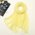 Détail d'une écharpe en mousseline jaune clair disposée à plat avec des accessoires en perles. - 170*70cm / Jaune vif