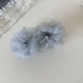 Primer plano de una pinza para el pelo de malla gris con elegante textura de organza - Clip de Plátano con Volantes / Azul