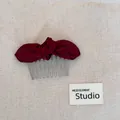 Macro close-up of a burgundy satin bow hair comb on a minimalist neutral fabric background - Bow Hair Comb