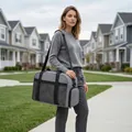 Grand sac de voyage gris porté par un mannequin dans une rue de banlieue - Taille unique / Gris