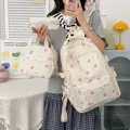 Vista detallada del juego de 3 mochilas con un lindo patrón de lazos rosas y puntos. - Beige