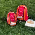 Trendiger orange-roter Wanderrucksack für Outdoor-Sport und Reisen auf grünem Gras - L / Rot
