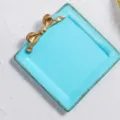 Plateau vintage en résine bleu clair avec nœud doré décoratif pour bijoux et accessoires - Carré Bleu
