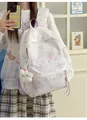 Detailansicht des weißer Rucksacks mit Sternmuster, lila Akzenten und Plüsch-Anhänger. - Mit Anhänger / Lila