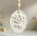 Detailed close-up view of lily of the valley embossed white plaster aromatherapy pendant - Lily of the Valley (Unscented)