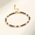 Close-up of a multi-colored beaded bracelet with gold-tone hardware and crystal beads - Smoky Quartz