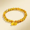 Elegantes gelbes Tigerauge-Perlenarmband mit goldenen Lotus- und Glockenanhängern - Goldenes Tigerauge | Alles nach Wunsch