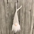 Vista detallada de un gnomo de Navidad de punto blanco con lentejuelas y barba suave. - Oro Arroz