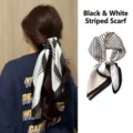 Detailed view of a black and white striped silk scarf being used as a stylish ponytail hair tie - LQ-3
