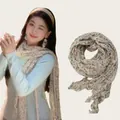 Lightweight pleated cotton-linen scarf with delicate floral print worn by a model - Floral Beige