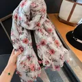 Macro view of lightweight soft floral print scarf featuring delicate pink tassel edges. - 180cm / Cherry Blossom Whispers