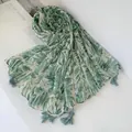 Detailed view of a lightweight scarf featuring tropical green leaf print and tassels. - 180cm / Green Leaf