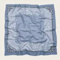 Detail view of a blue square scarf with delicate floral prints and wavy borders. - 110X110CM / Blue Gradient Floral