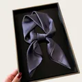 Close-up of a luxurious grey silk neck scarf tied in a knot in a black tray. - 68cm / Dark Gray