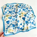 Dettaglio di un foulard quadrato di seta con eleganti cuori blu e bordo azzurro - 70cm / Blu