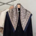 Detailansicht eines Seidenschals mit Vintage-Paisleymuster auf einem schwarzen Cardigan - 68cm x 68cm / Champagner