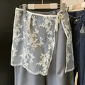 Dettaglio della gonna sovrapposta in pizzo di organza con ricami floreali bianchi. - Taglia unica / Pantaloni e gonne / Filigrana Vintage