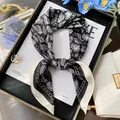 Elegante pañuelo de seda con estampado paisley blanco y negro anudado para decorar. - Alquitrán Estético - Negro